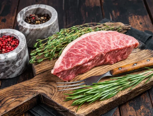 Carne wagyu cruda con marmoleo perfecto en una tabla de madera